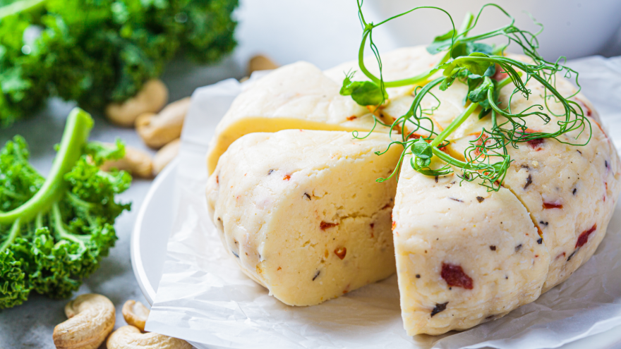 Ein veganer Käse aus Cashewkernen liegt auf einem Teller