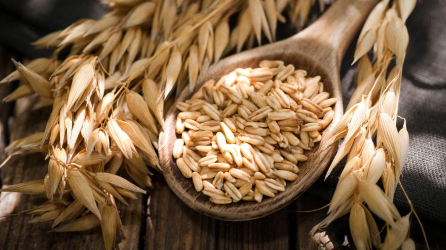 Haferkörner in einer Schüssel und eine Haferähre