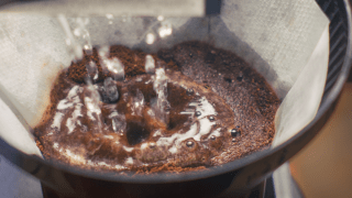 Heißes Wasser fließt in einen Kaffeefilter