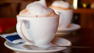 Zwei Tassen mit Kaffee, auf denen Milchschaum zu sehen ist